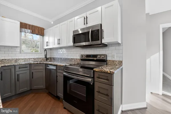 a kitchen with stainless steel appliances granite countertop a stove microwave and sink