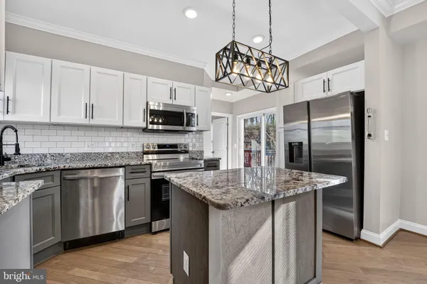 a kitchen with stainless steel appliances granite countertop a sink refrigerator and microwave