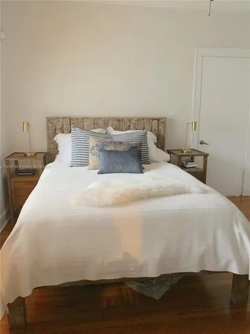 a large bed sitting in a bedroom next to a window