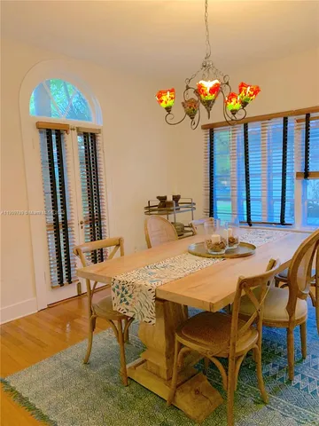a dining room filled chandelier and wooden floor