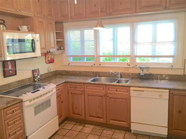 a kitchen with a sink stove top oven and cabinets