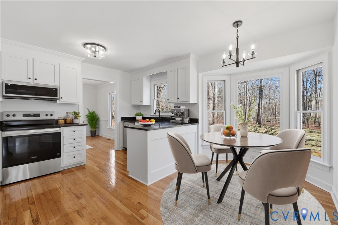 3264 Sherwood Ridge Way Powhatan, VA 23139 - Photo 8 of 40 a kitchen with stainless steel appliances a dining table chairs and a refrigerator