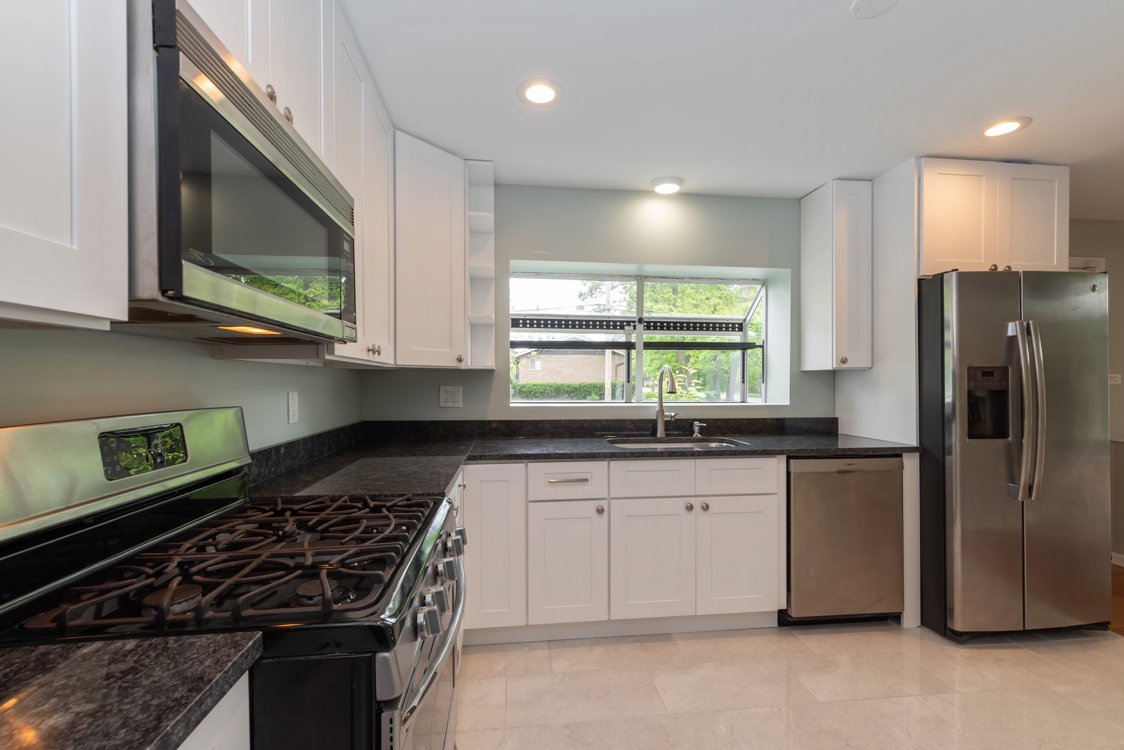 1682 Berkeley Road Highland Park, IL 60035 - Photo 5 of 15 a kitchen with stainless steel appliances granite countertop a stove a sink and a microwave