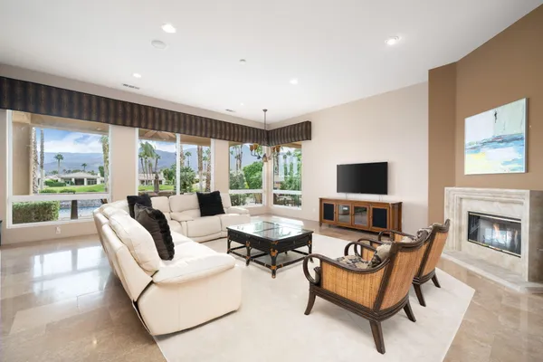 a living room with furniture a fireplace and a flat screen tv