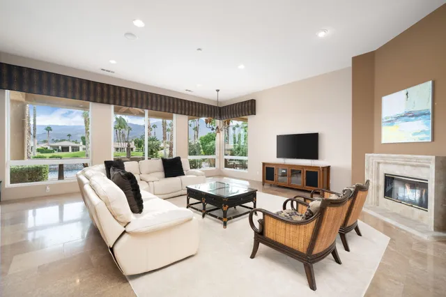 a living room with furniture a fireplace and a flat screen tv