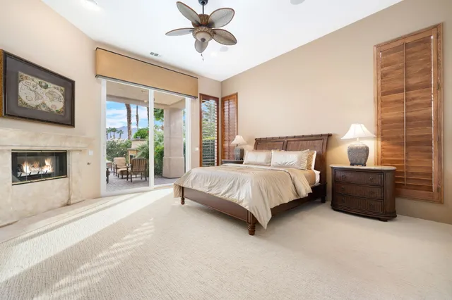 a bedroom with a large bed and a chandelier fan