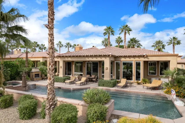 a view of a patio with couches table and chairs potted plants and palm tree