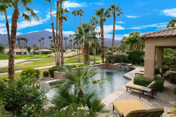 a view of a patio with table and chairs potted plants and palm tree