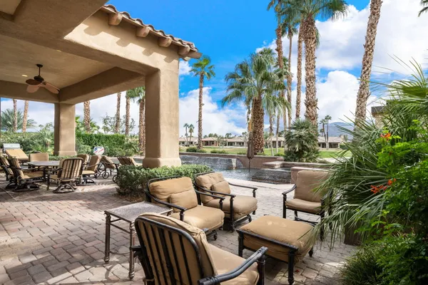 a view of a patio with couches chairs and swimming pool
