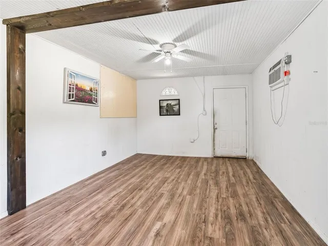 a view of a room with wooden floor and a ceiling fan