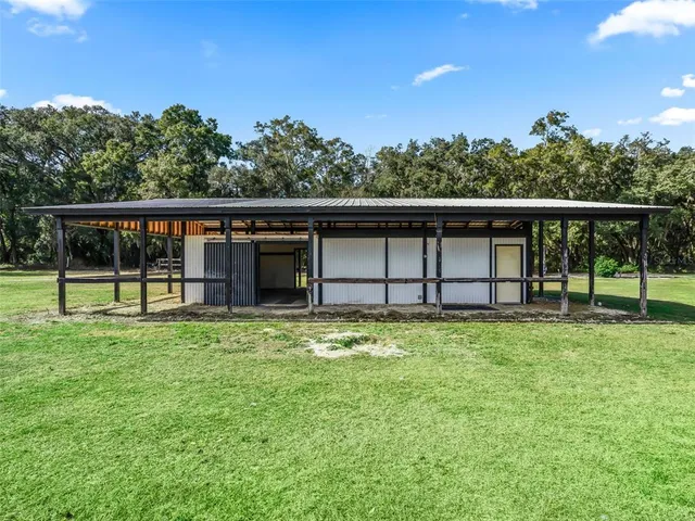a view of a deck with a big yard and large trees