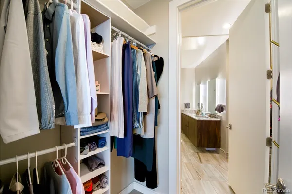 a view of walk in closet with clothes and shoes