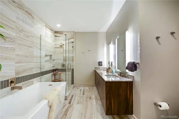 a bathroom with a tub sink and mirror