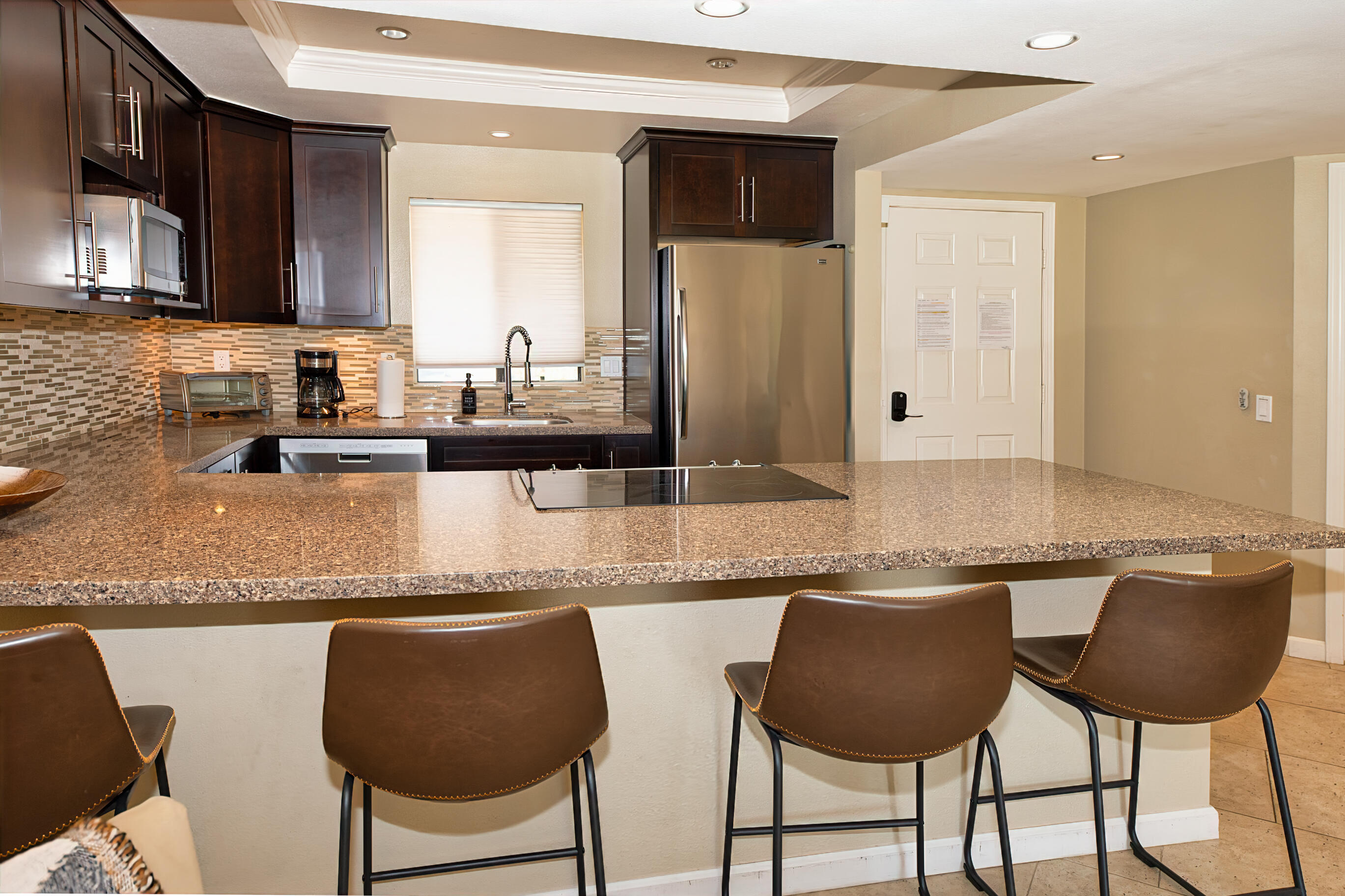 77361 Preston Trail Palm Desert, CA 92211 - Photo 12 of 47 a kitchen with granite countertop a counter space chairs cabinets and stainless steel appliances