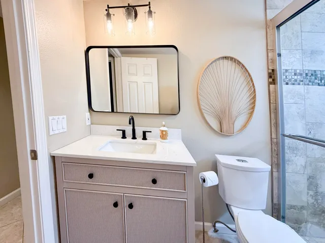 a bathroom with a sink mirror vanity and toilet