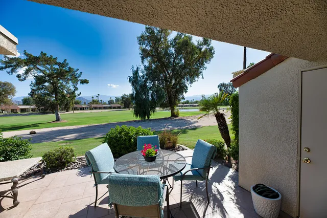 a view of a chairs and table in patio with a yard