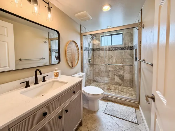 a kitchen with granite countertop a counter space chairs cabinets and stainless steel appliances