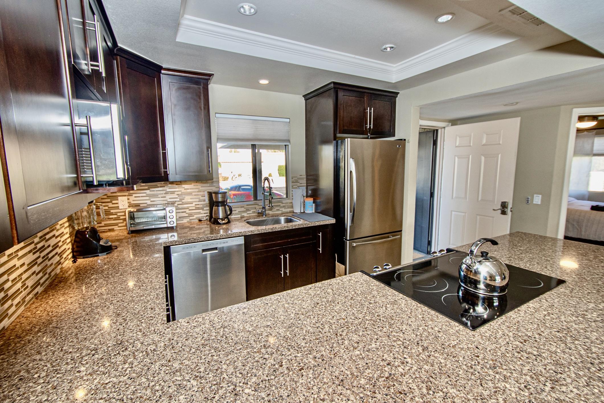77361 Preston Trail Palm Desert, CA 92211 - Photo 5 of 47 a kitchen with stainless steel appliances kitchen island granite countertop a sink refrigerator and cabinets
