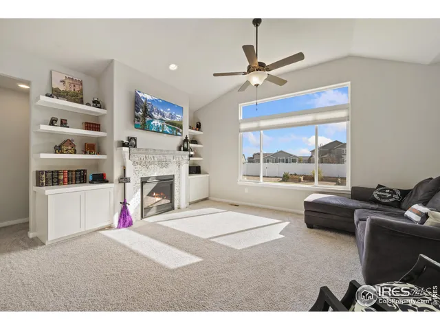 a living room with furniture a fireplace and a large window