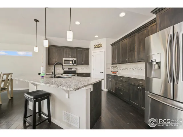 a kitchen with stainless steel appliances granite countertop a sink refrigerator and cabinets