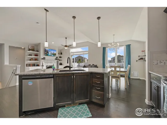 a kitchen with stainless steel appliances granite countertop a sink a stove and chairs
