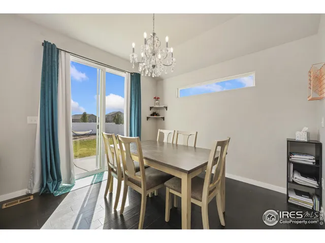 a view of a dining room with furniture a chandelier and wooden floor