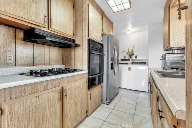 a kitchen with stainless steel appliances granite countertop a stove a refrigerator and a sink