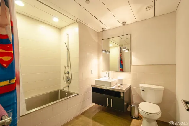 a bathroom with a bathtub shower sink mirror vanity and toilet