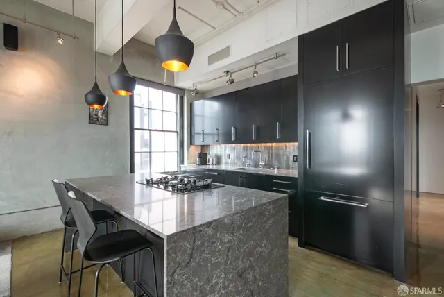 a kitchen with a table chairs refrigerator and cabinets
