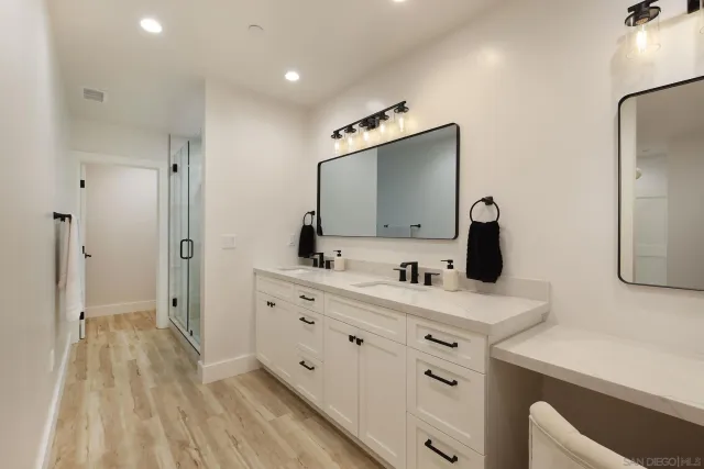 a bathroom with a double vanity sink mirror and shower