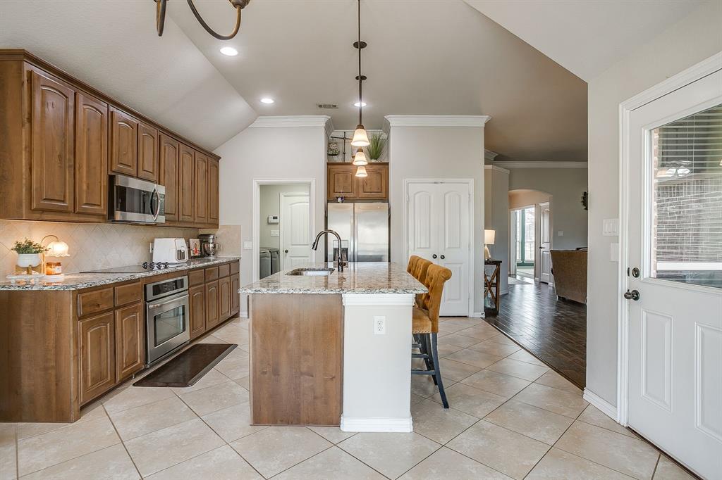 8005 Canyon Ridge Drive Godley, TX 76044 - Photo 14 of 40 a large kitchen with kitchen island granite countertop lots of white stainless steel appliances