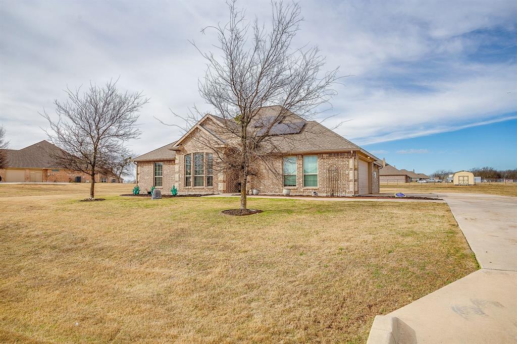 8005 Canyon Ridge Drive Godley, TX 76044 - Photo 3 of 40 a yellow house with trees in front of it
