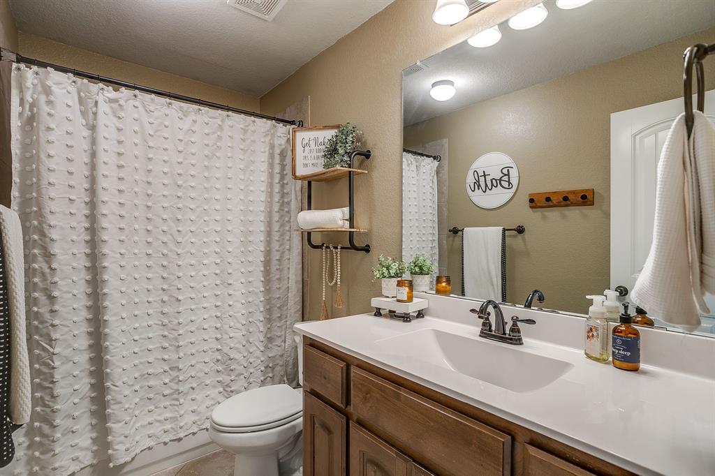 8005 Canyon Ridge Drive Godley, TX 76044 - Photo 31 of 40 a bathroom with a sink a toilet and a mirror