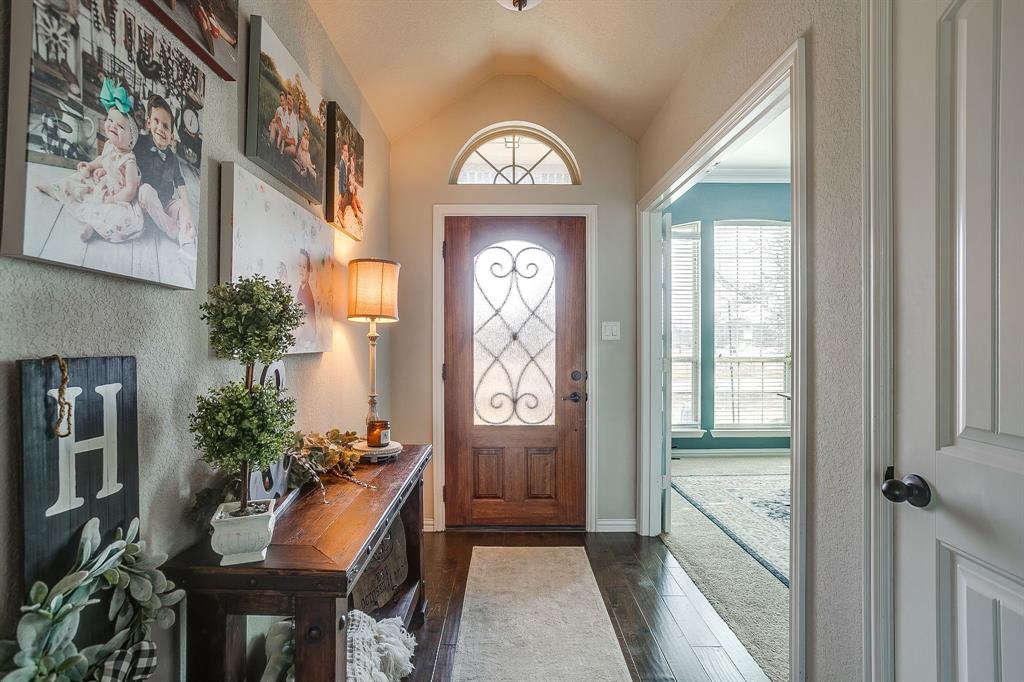 8005 Canyon Ridge Drive Godley, TX 76044 - Photo 5 of 40 a view of a hallway with wooden floor and a chandelier