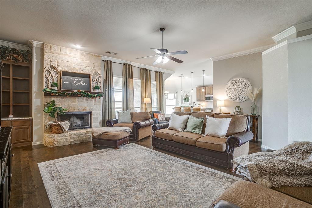 8005 Canyon Ridge Drive Godley, TX 76044 - Photo 7 of 40 a living room with furniture a fireplace and a chandelier