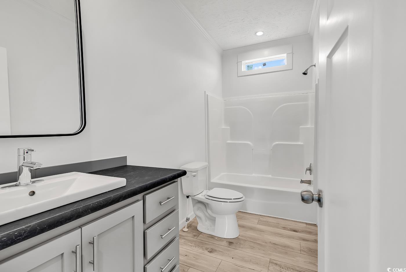 7768 Kerl Road Conway, SC 29526 - Photo 17 of 40 Full bathroom featuring a textured ceiling, wood finished floors, toilet, vanity, and shower / tub combination