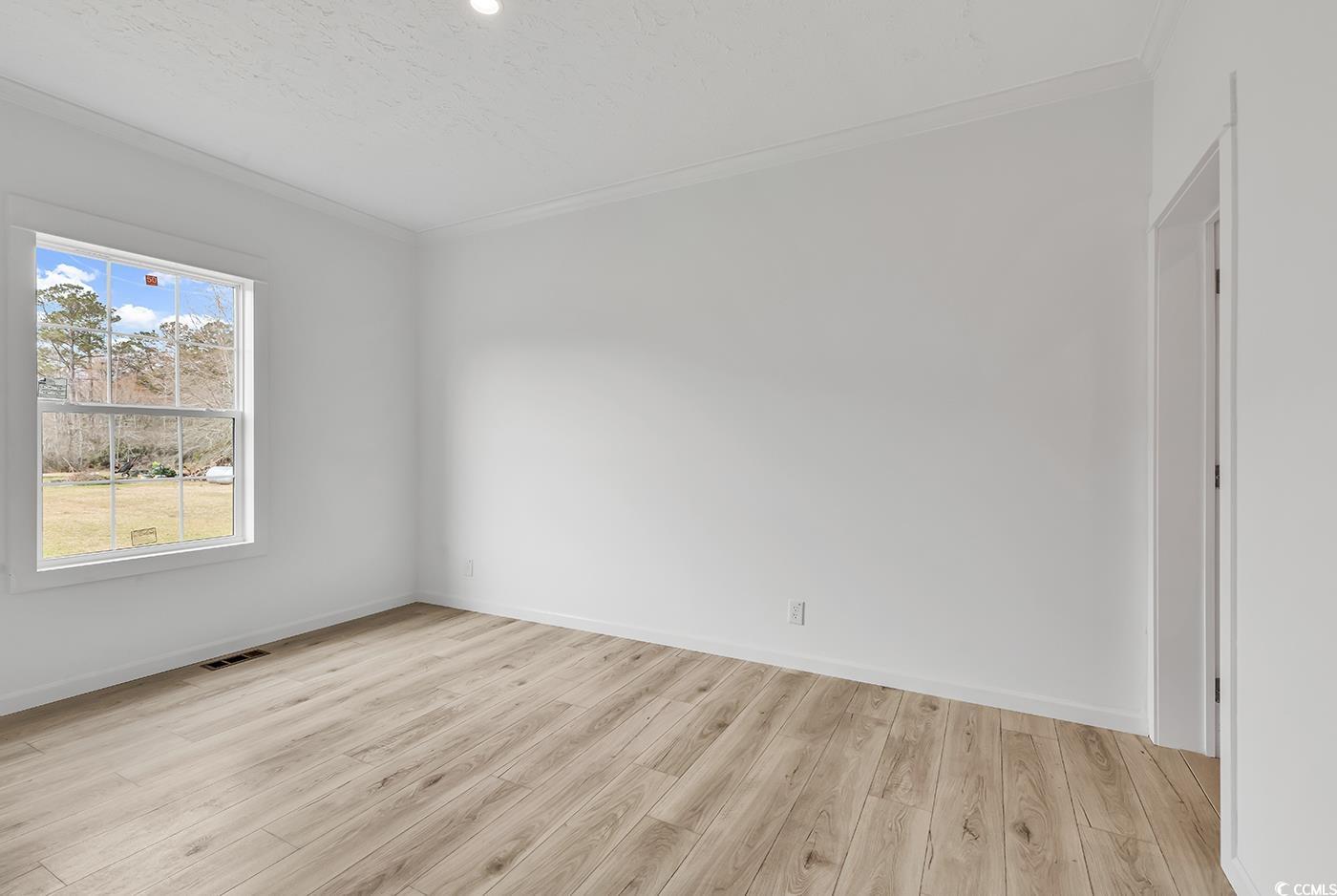7768 Kerl Road Conway, SC 29526 - Photo 33 of 40 Spare room featuring light wood-type flooring, crown molding, baseboards, and visible vents