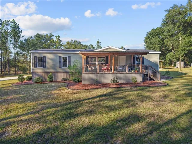 a view of a house with pool and chairs