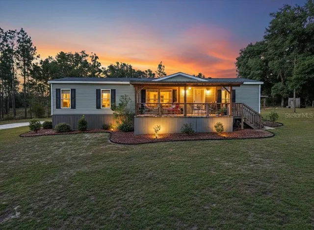 a front view of house with yard and trees in the background