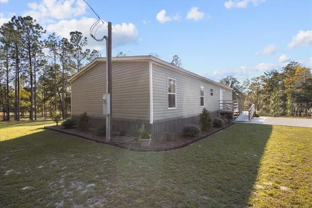 a view of a house with backyard and trees