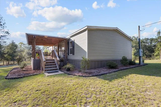 a view of a house with backyard and sitting area