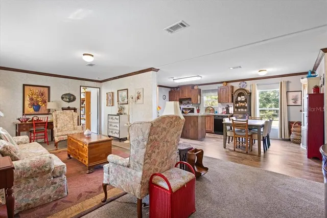 a view of a dining room with furniture a kitchen and chandelier