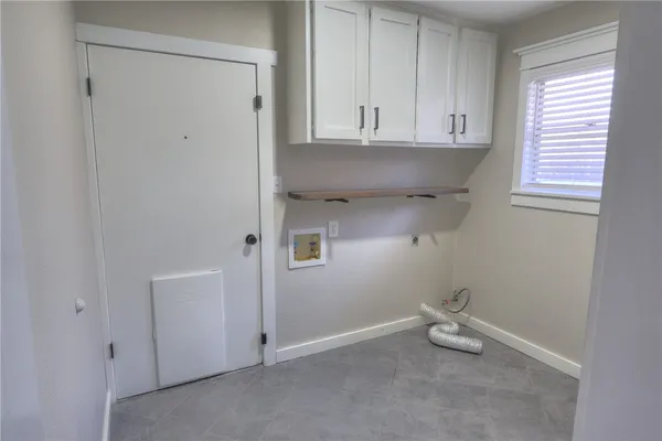 a view of cabinets and utility room with a window