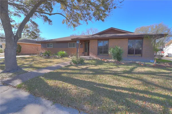 a front view of a house with a yard and potted plants