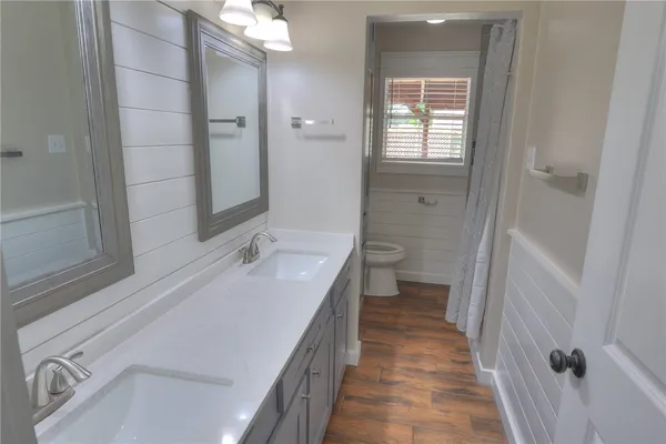 a bathroom with a sink a toilet and shower