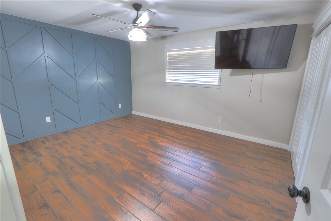 5209 Bromley Drive Corpus Christi, TX 78413 - Photo 26 of 31 an empty room with wooden floor fan and windows