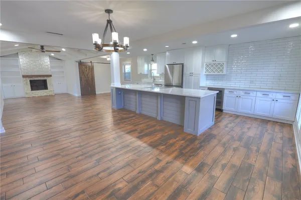 a large kitchen with granite countertop a large counter top space and stainless steel appliances