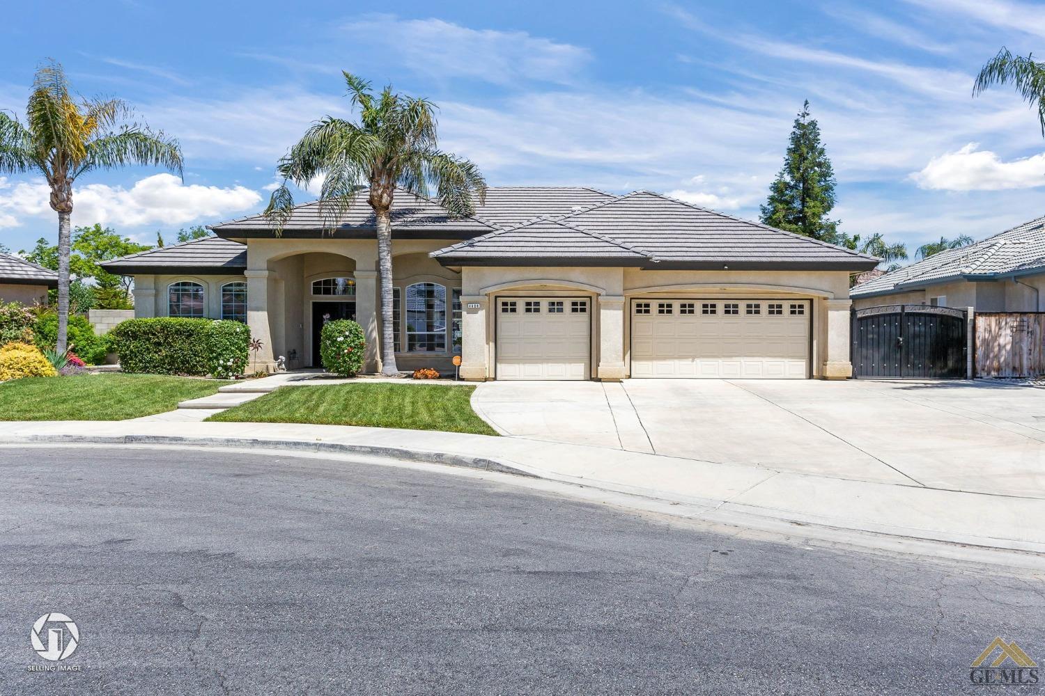 a view of a white house with a yard and potted plants