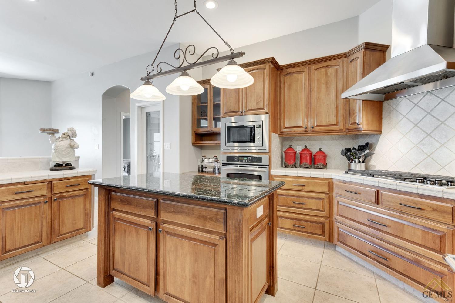 Undisclosed Address Bakersfield, CA 93313 - Photo 20 of 50 a kitchen with granite countertop a sink stainless steel appliances and cabinets