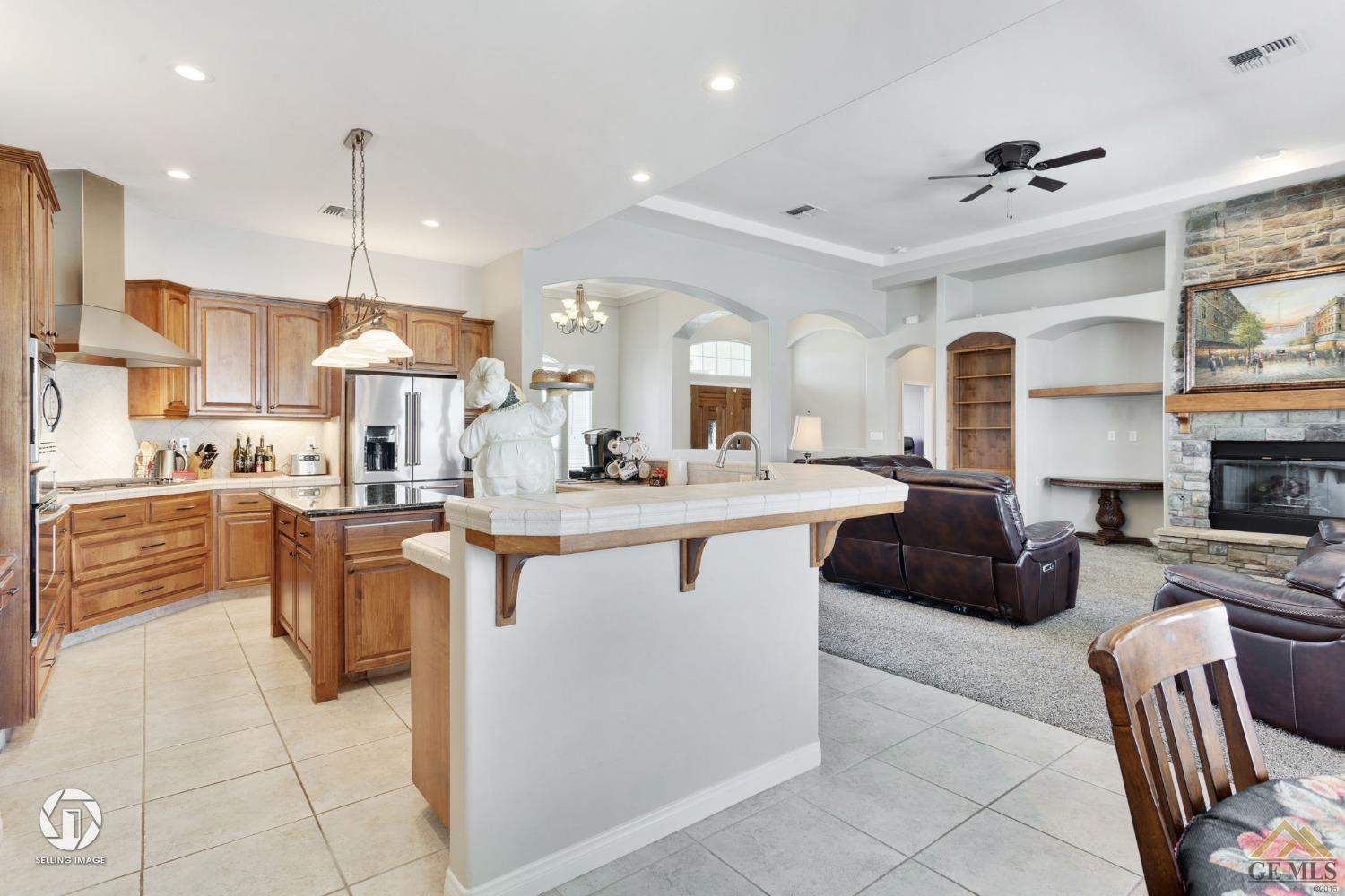 Undisclosed Address Bakersfield, CA 93313 - Photo 22 of 50 a kitchen with stainless steel appliances kitchen island granite countertop a sink and a refrigerator